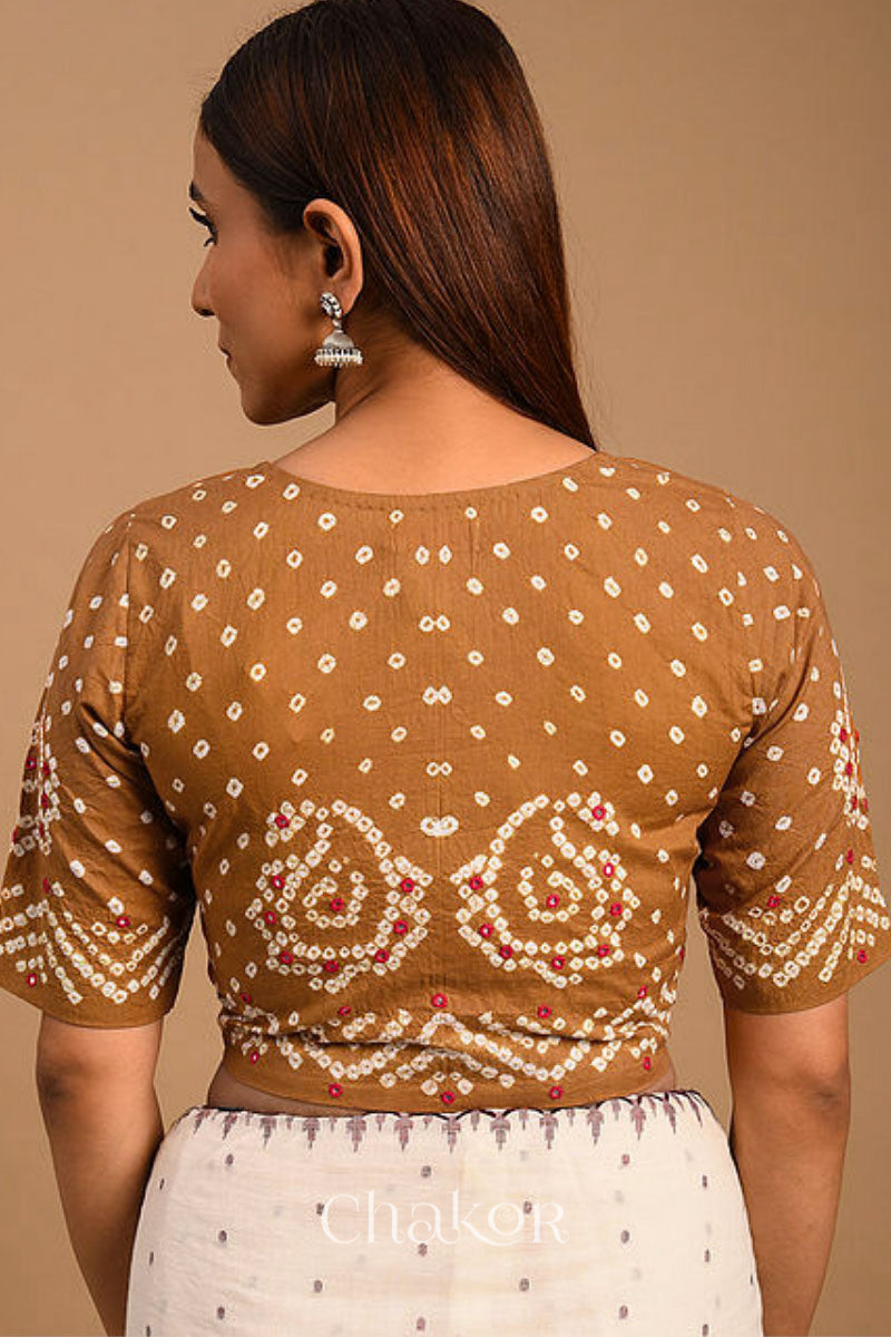 A woman wearing a traditional Mustard Yellow Bandhani Cotton Blouse with intricate mirror embroidered Keri - Paisley motifs and boria fabric buttons.
