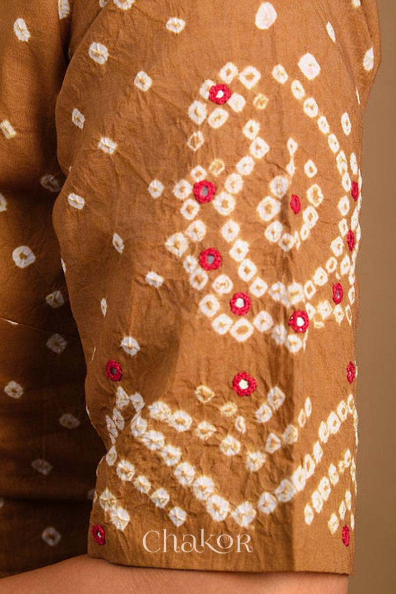 A woman wearing a traditional Mustard Yellow Bandhani Cotton Blouse with intricate mirror embroidered Keri - Paisley motifs and boria fabric buttons.