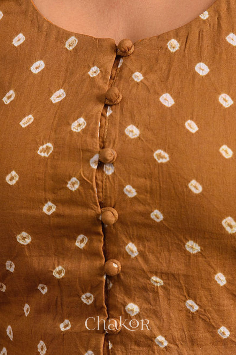 A woman wearing a traditional Mustard Yellow Bandhani Cotton Blouse with intricate mirror embroidered Keri - Paisley motifs and boria fabric buttons.