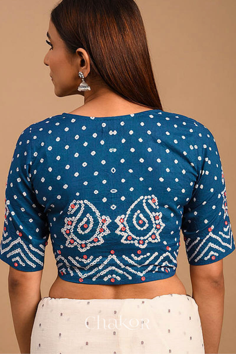 A woman wearing a traditional Indigo Blue Bandhani Cotton Blouse with intricate mirror embroidered Keri - Paisley motifs and boria fabric buttons.