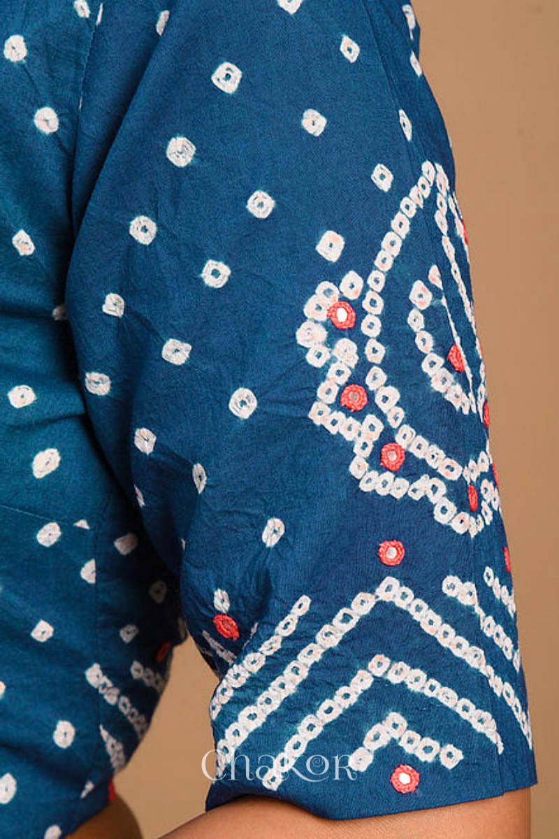 A woman wearing a traditional Indigo Blue Bandhani Cotton Blouse with intricate mirror embroidered Keri - Paisley motifs and boria fabric buttons.