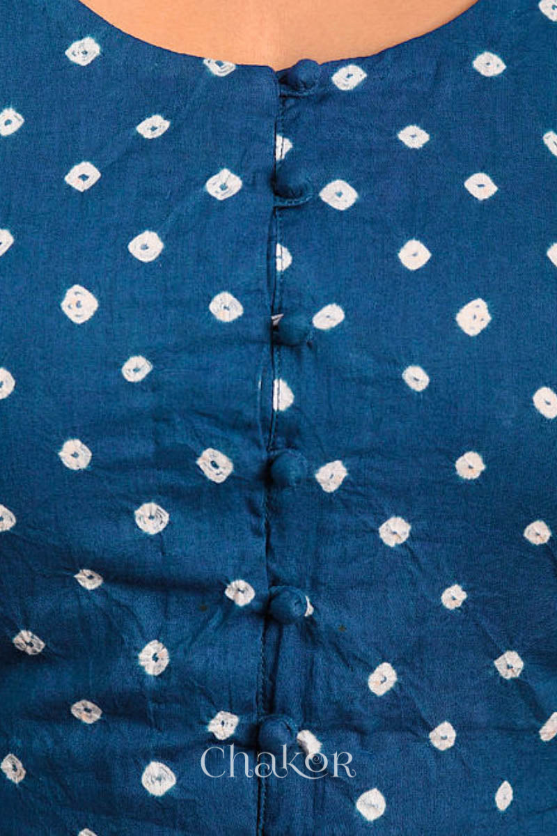 A woman wearing a traditional Indigo Blue Bandhani Cotton Blouse with intricate mirror embroidered Keri - Paisley motifs and boria fabric buttons.