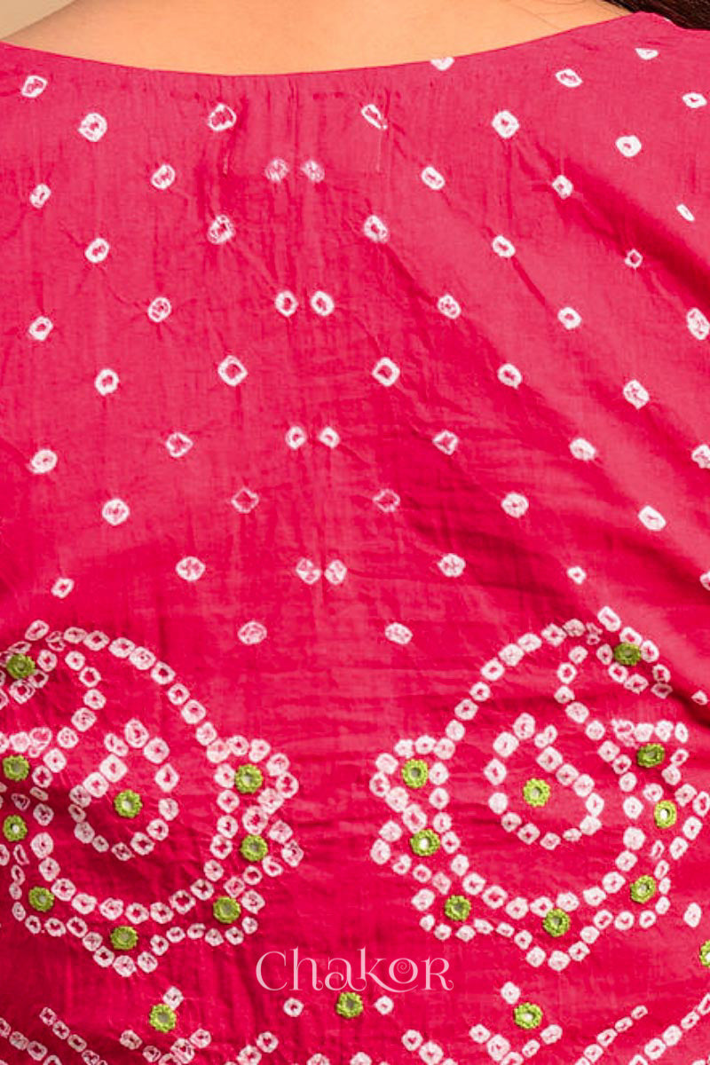 A woman wearing a traditional Strawberry Pink Bandhani Cotton Blouse with intricate mirror embroidered Keri - Paisley motifs and boria fabric buttons.