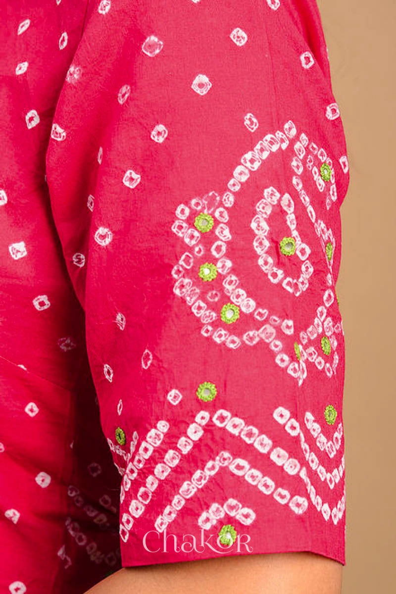 A woman wearing a traditional Strawberry Pink Bandhani Cotton Blouse with intricate mirror embroidered Keri - Paisley motifs and boria fabric buttons.