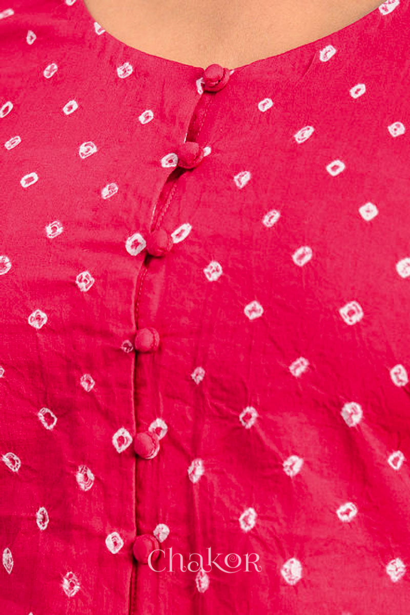 A woman wearing a traditional Strawberry Pink Bandhani Cotton Blouse with intricate mirror embroidered Keri - Paisley motifs and boria fabric buttons.